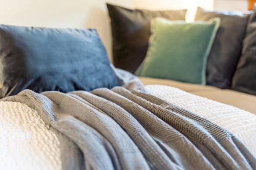 a couch with pillows and a blanket on it at Suflora in Mengara
