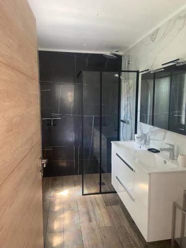 La salle de bains est pourvue d'une douche et d'un lavabo blanc. dans l'établissement Haut de villa avec jardin et vue dégagée, à Vence