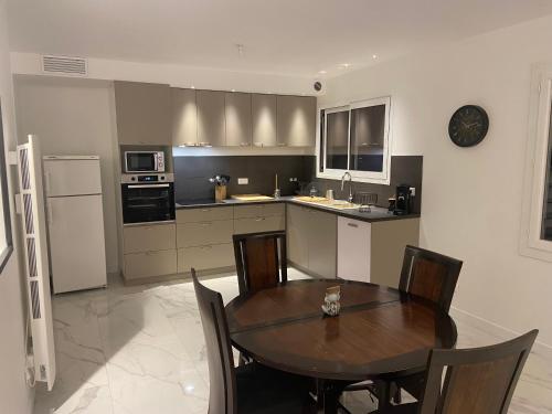 une cuisine avec une table en bois et une salle à manger dans l'établissement Haut de villa avec jardin et vue dégagée, à Vence