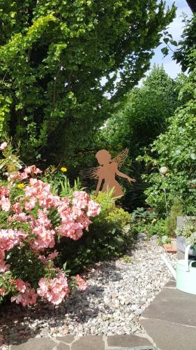 a garden with pink flowers and a statue of an angel at Landhaus Strickenmacher in Sillian