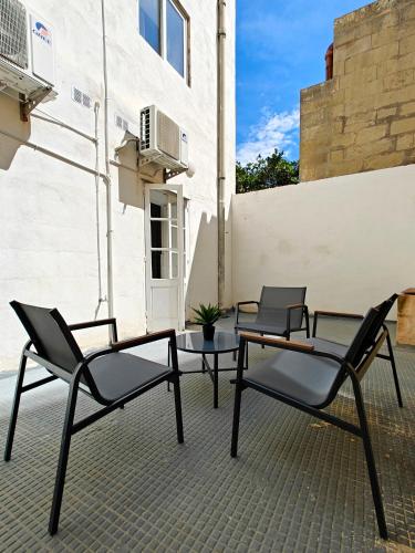 three chairs and a table on a patio at Cosyroom 3 in Pieta