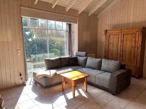 a living room with a couch and a table at Ferienhaus Bungalow Schloß Dankern für 6 Personen in Haren