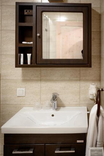 a bathroom with a white sink and a mirror at Păstrăvăria Alex in Mara