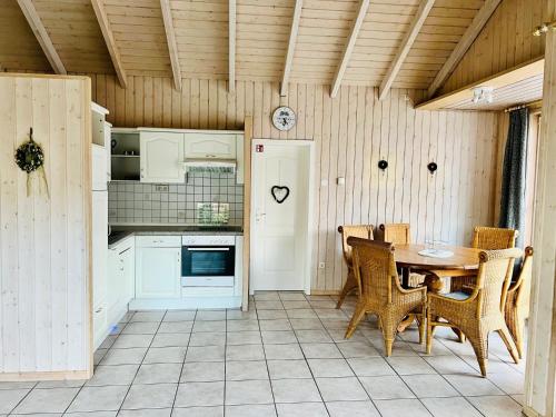 a kitchen with a table and chairs in a room at Ferienhaus Bungalow Schloß Dankern für 6 Personen in Haren