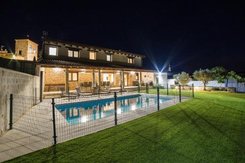 a house with a swimming pool at night at Casa Rural: La Tarara in Galinduste