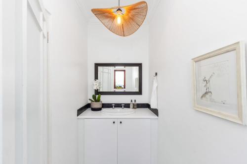 un baño con lavabo y espejo en Winelands Villa by Host Agents, en Ciudad del Cabo