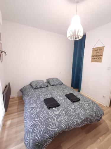 - une chambre avec un lit et 2 serviettes noires dans l'établissement T3 proche gare, 2chs, 3lits, wifi, parking, à Agen