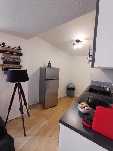 - une cuisine avec un comptoir, un réfrigérateur et une table dans l'établissement T3 proche gare, 2chs, 3lits, wifi, parking, à Agen