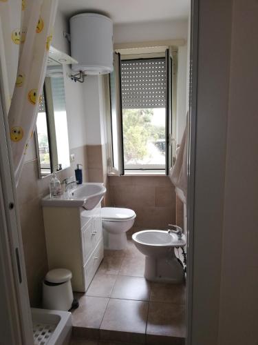 a bathroom with two sinks and a toilet and a window at GioCla in Cassino