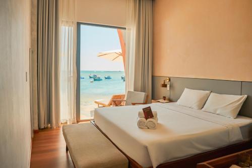une chambre avec un lit avec vue sur la plage dans l'établissement L'amant Boutiqué House Phú Quý, à Cu Lao Thu