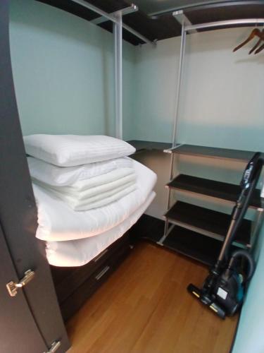 a room with a stack of pillows and a closet at 바다스테이 in Busan