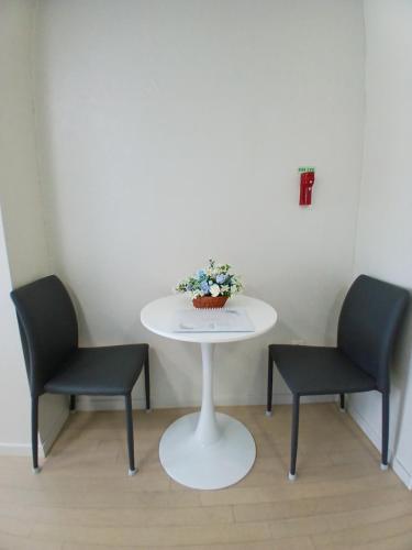 two chairs and a white table with a plant on it at 바다스테이 in Busan