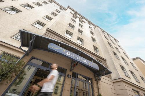 a man walking in front of a building at myNext - Hotel Rudy in Vienna