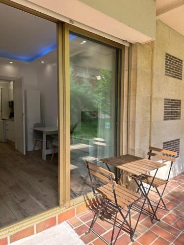 un patio avec une table, des chaises et une fenêtre dans l'établissement Deauville Studio - Proche mer, à Deauville