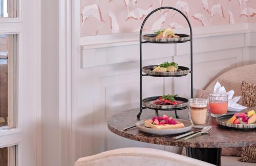 a tray of food on a table with plates of food at Hotel Alden Splügenschloss Zürich - Leonardo Limited Edition in Zürich