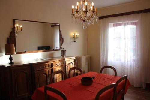 a dining room with a red table and a mirror at Homestay Château De Saint-Maixant in Saint-Maixant