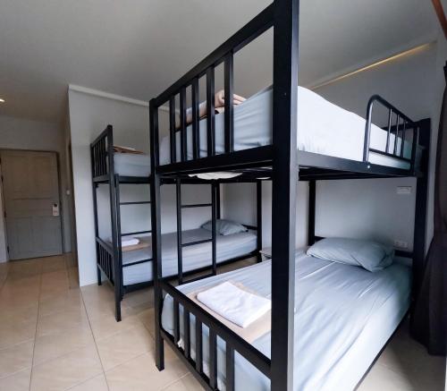 a room with three bunk beds with white sheets at Chaweng Terrace in Chaweng