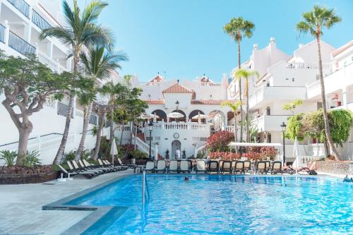 a swimming pool in front of a building with palm trees at Ona Beverly Hills Heights in Los Cristianos