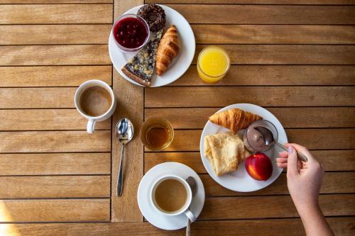 a table with two plates of breakfast foods and coffee at Kapka resort in Vsetín