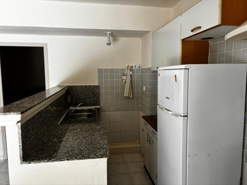 eine Küche mit einem weißen Kühlschrank und einer Spüle in der Unterkunft Bon Porto 2 in Cavalaire-sur-Mer