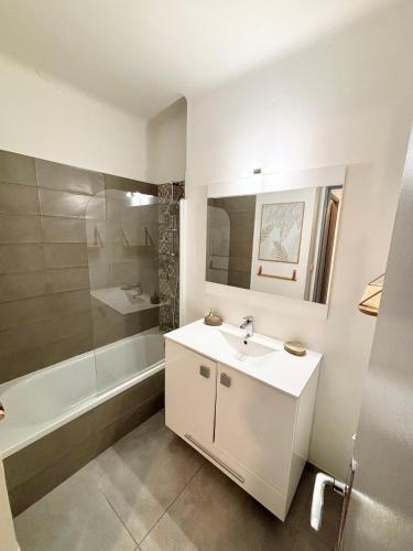 une salle de bain blanche avec un lavabo et une baignoire dans l'établissement Magnifique T2 avec Terrasse, à Aix-en-Provence