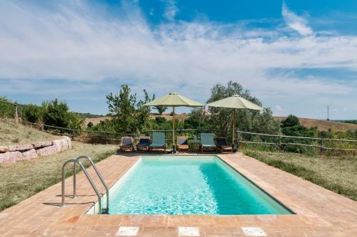 a swimming pool with two chairs and umbrellas at Banditella in Orvieto