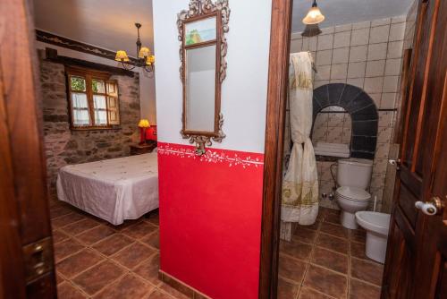 QuintanaにあるApartamentos Rurales Ca Xuacu La Antojanaの寝室に通じる赤いドアのあるバスルーム