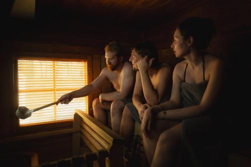 a group of naked men sitting on a bed looking out a window at Vaattunki Wilderness Resort in Rovaniemi