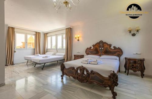 a bedroom with two beds and a chandelier at Villa del Mar in Torremolinos