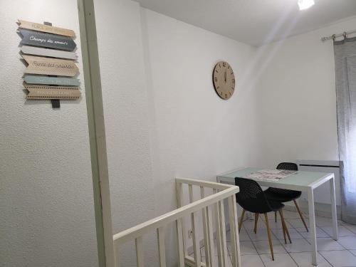 une pièce avec une table et une horloge au mur dans l'établissement studio amande, proche gare, wifi, à Agen