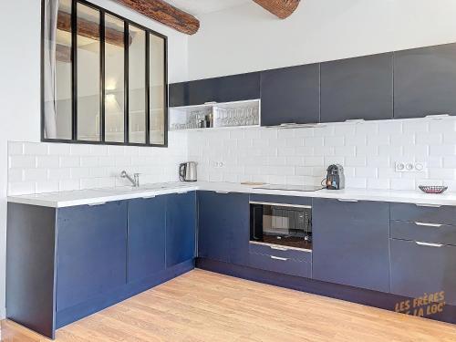une cuisine avec des armoires bleues et un évier dans l'établissement Charmant Appartement au Vieux-Port - Climatisation - Les Frères de la Loc', à Marseille