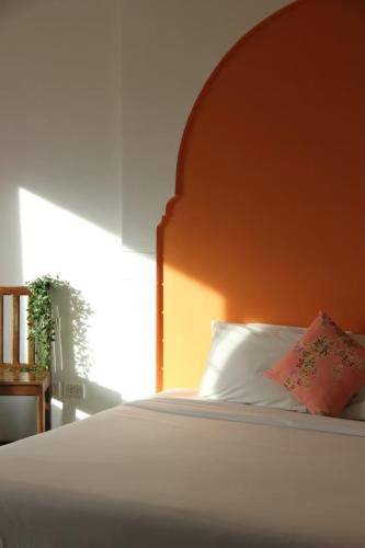 a bed with a wooden headboard and a pillow at Dinar Lodge in Bang Tao Beach
