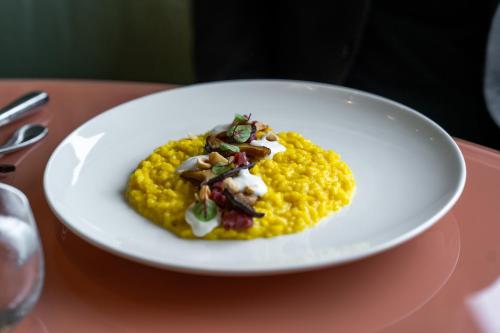 a white plate with a dish of food on a table at Plaza Hotel Abano Terme in Abano Terme