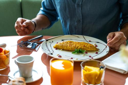 a person sitting at a table with a plate of food at Plaza Hotel Abano Terme in Abano Terme