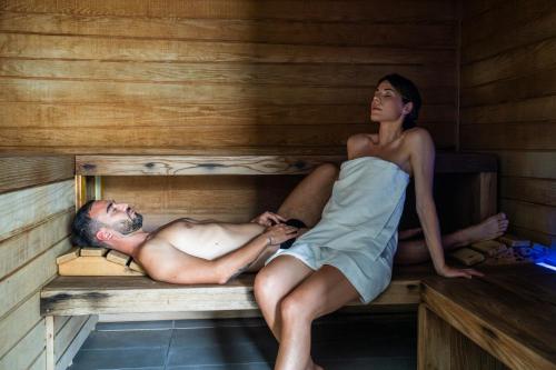 a man and a woman sitting in a sauna at Plaza Hotel Abano Terme in Abano Terme