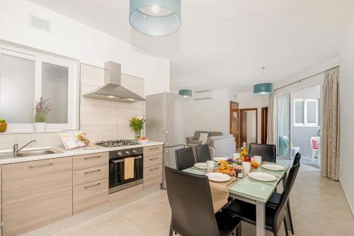 a kitchen and dining room with a table and chairs at Hillock Residence Apartments in Marsalforn