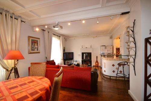 un salon avec un canapé rouge et une table dans l'établissement Great apartment near rue Daguerre, à Paris