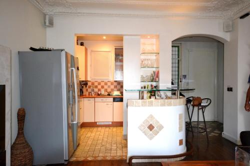 Il comprend une cuisine équipée d'un réfrigérateur et d'une table. dans l'établissement Great apartment near rue Daguerre, à Paris