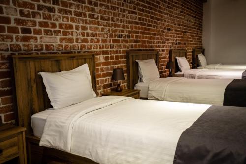 two beds in a room with a brick wall at Shamuk Homes in Chimgan
