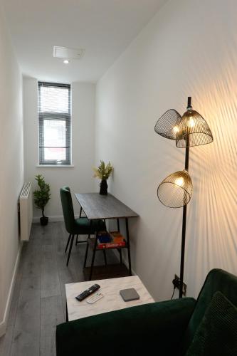 a living room with a table and a lamp at Luxe Apartment - Leicester City Centre in Leicester