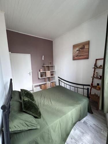 une chambre avec un lit avec une couette verte dans l'établissement MH Logement - Chaleureuse maison scandinave, à Nîmes
