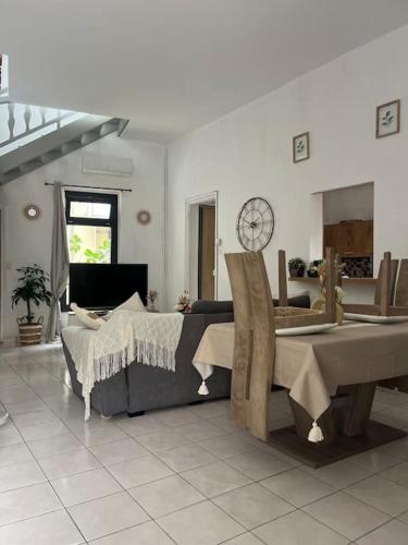 un salon avec un lit et une table dans l'établissement MH Logement - Chaleureuse maison scandinave, à Nîmes