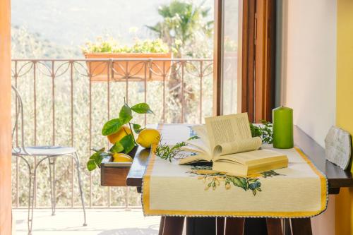 a table with an open book on a balcony at Azienda Agrituristica Bergi in Castelbuono