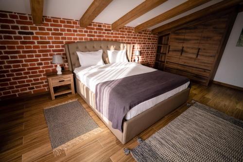a bedroom with a bed and a brick wall at Shamuk Homes in Chimgan