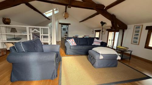 a living room with two blue chairs and a couch at Domaine La Barbe ! in Lalanne-Arqué