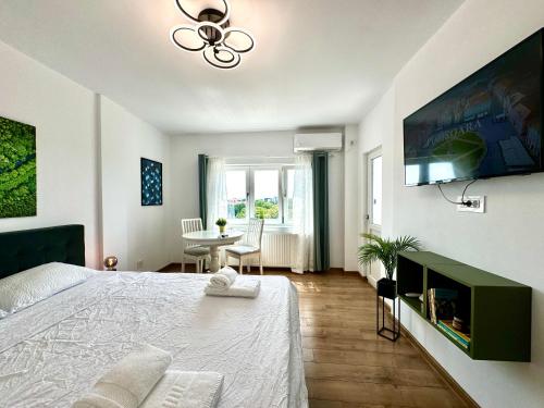 a bedroom with a bed and a table and a window at Park View Studio in Timişoara