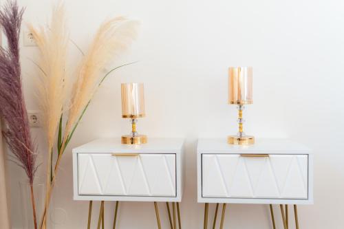 a pair of white nightstands with gold poles at VDG Seafront Elegant Residence in Rethymno Town