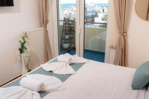 a bed with towels sitting on top of it at VDG Seafront Elegant Residence in Rethymno Town