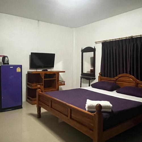 a bedroom with a large bed and a tv at บ้านพักสิริ มุกดาหาร (Baan Siri Mukdahan) in Ban Muang Ba
