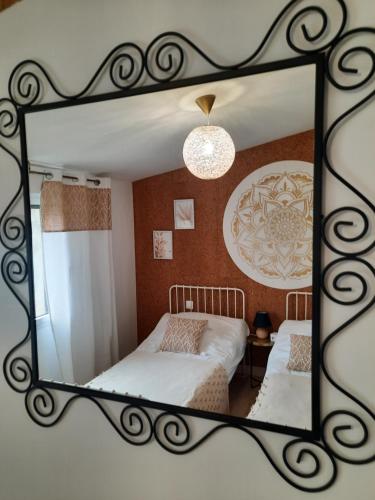 a mirror of a bedroom with a bed in a room at gîte grange le Kulmino in Notre-Dame-de-Monts